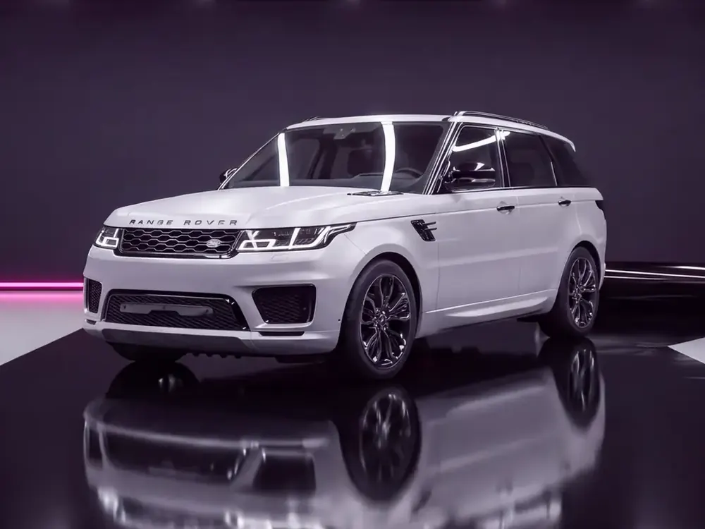 A white Range Rover Sport with its chrome trim wrapped in gloss black